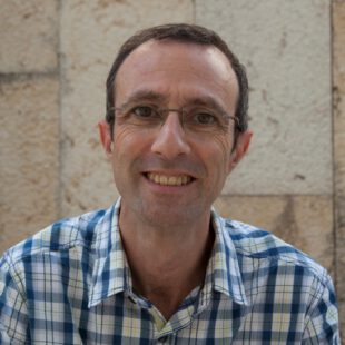 Porträt-Foto des Illustrators Darius Gilmont im karierten Hemd und mir rahmenloser Brille