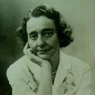 Porträt-Foto der Autorin Leah Goldberg: Eine Frau mit kurzem lockigen Bob, das Kinn in die Hand gestützt, sie trägt eine weiße Bluse und Perlenkette.