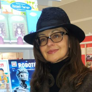 Marina B. Neubert Porträt-Foto der Autorin Marina B. Neubert vor ihren Büchern. Die Autorin trägt Brille und einen schwarzen Hut.